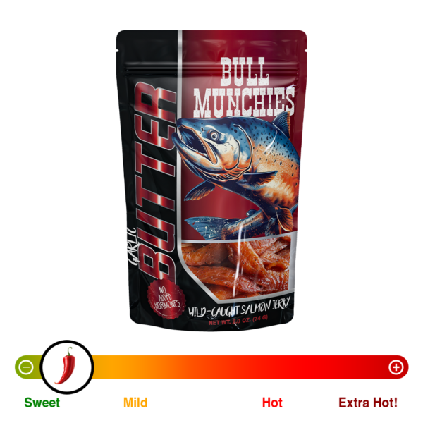 Packaging of Bull Munchies Wild-Caught Salmon Jerky in Garlic Butter flavor. The design features a detailed illustration of a large salmon in mid-leap against a red background. Text on the packaging highlights ‘No Added Hormones’ and the weight of the package as 2.0 oz (74g).