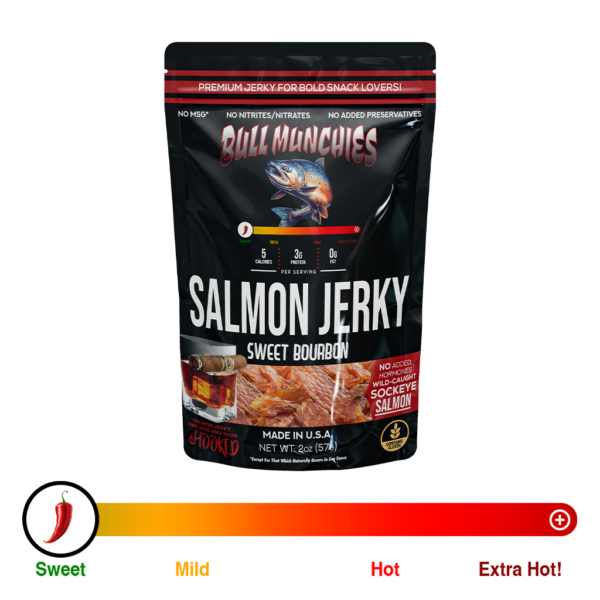 Bull Munchies Sweet Bourbon Salmon Jerky packaging featuring a bold design with a detailed illustration of a wild salmon. The product label highlights key information like ‘Sweet Bourbon,’ ‘Wild-Caught Salmon Jerky,’ and ‘No Added Hormones.’ The package displays a 2 oz (74 g) serving of the jerky with a vibrant image of the product inside, alongside a large, dynamic image of a leaping salmon.